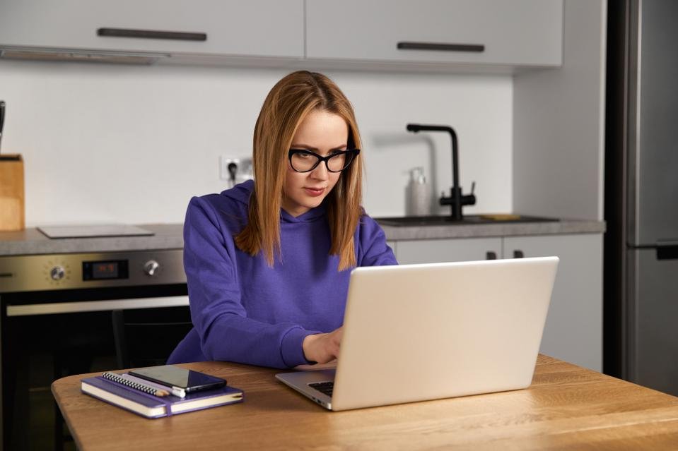 A woman works from home on her laptop