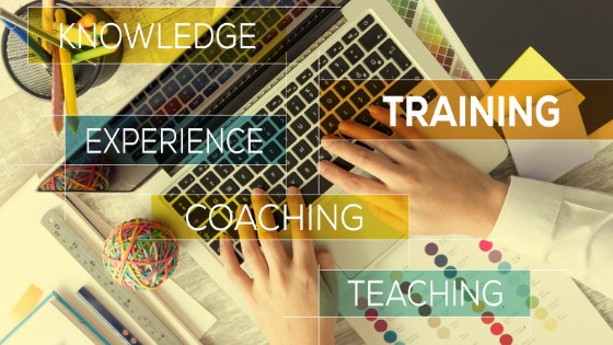 Hand on laptop keyboard with Training, Teaching, Coaching, Experience, and Knowledge labels