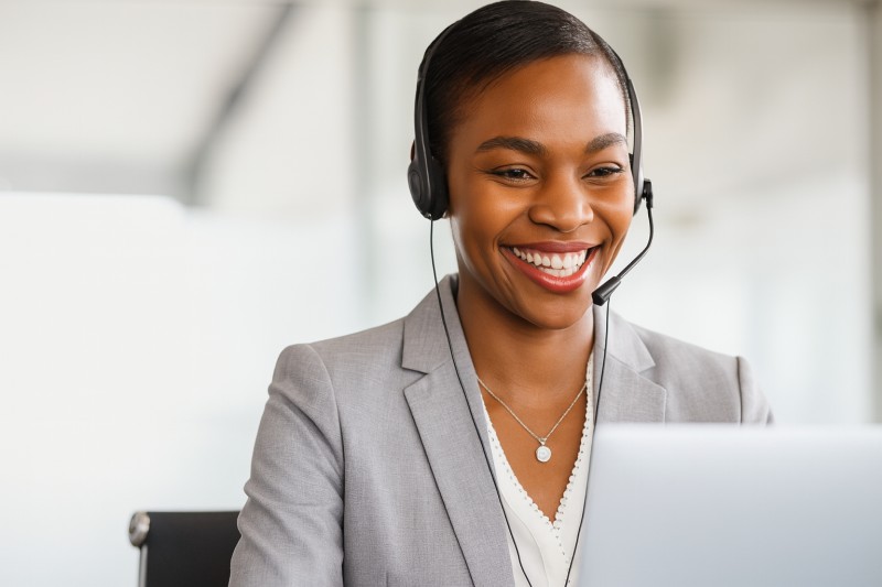 Smiling representative wearing headset in front of computer